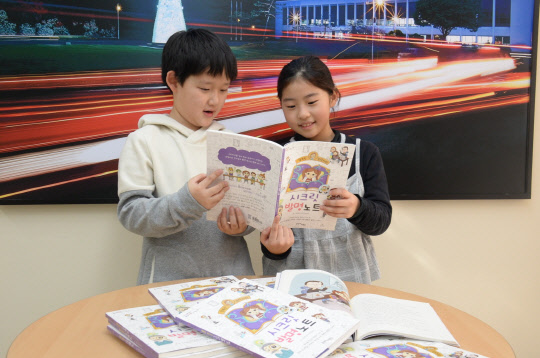 어린이들이 행복한 공학자의 발명비법을 동화로 소개한 '행복한 공학자의 시크릿 발명노트'를 보고 있다.  ETRI 제공